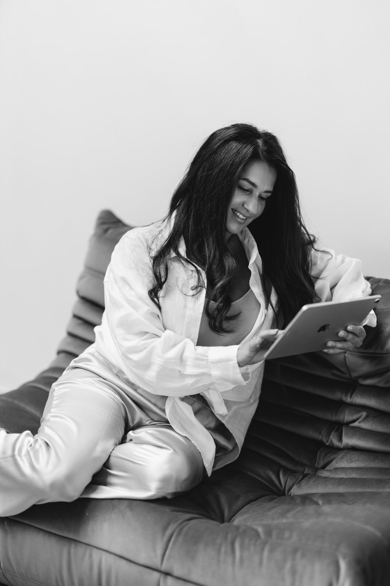 Fatima zit op de bank en kijkt glimlachend naar haar tablet