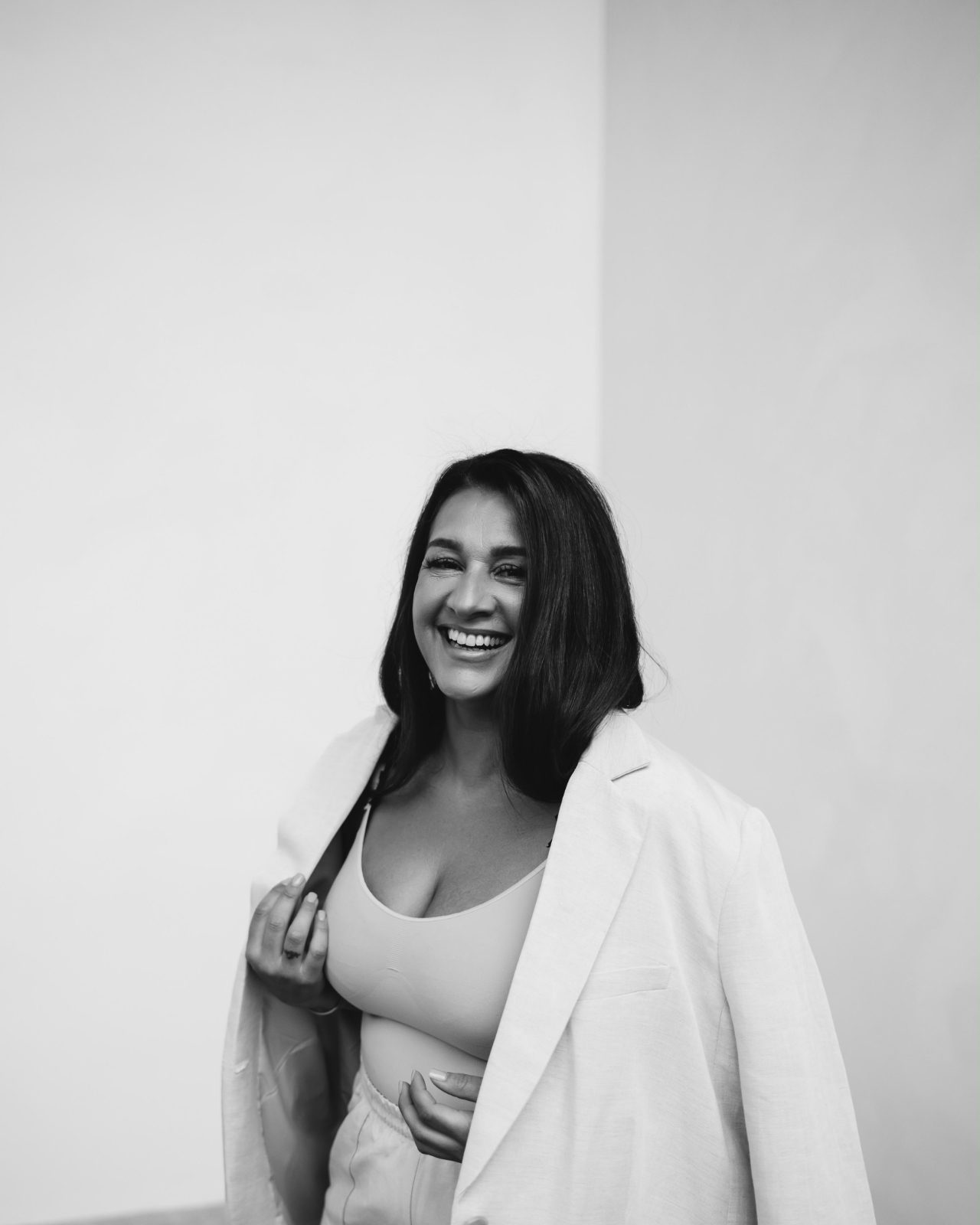 Fatima lacht in een lichte blazer, in zwart-wit